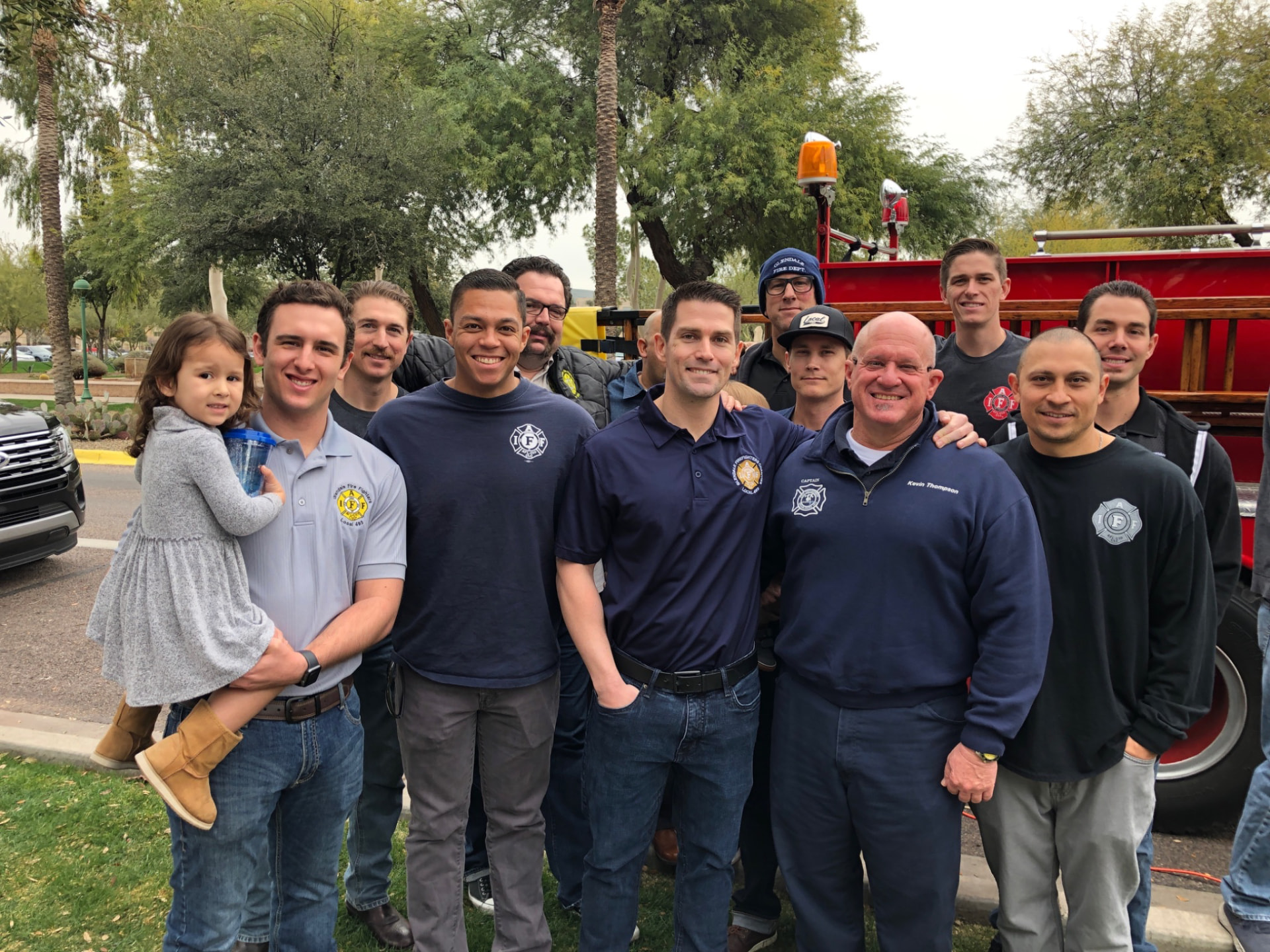 Glendale firefighters and family beside a vintage fire engine